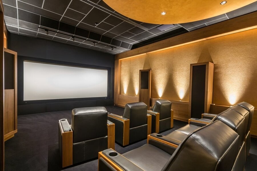 A luxury home theater design featuring high-end speakers, comfy seating, and a large screen display.