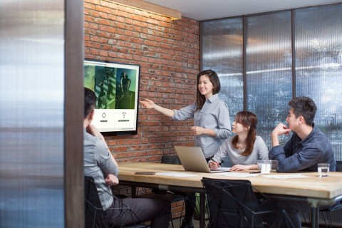 employees working in a remodeled conference room featuring videoconferencing and automation features by Crestron.