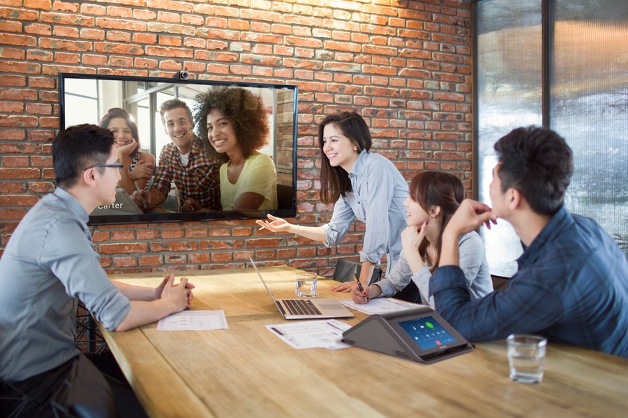 A team in an Oklahoma City office using Crestron’s commercial AV solutions for a hybrid meeting with remote participants.