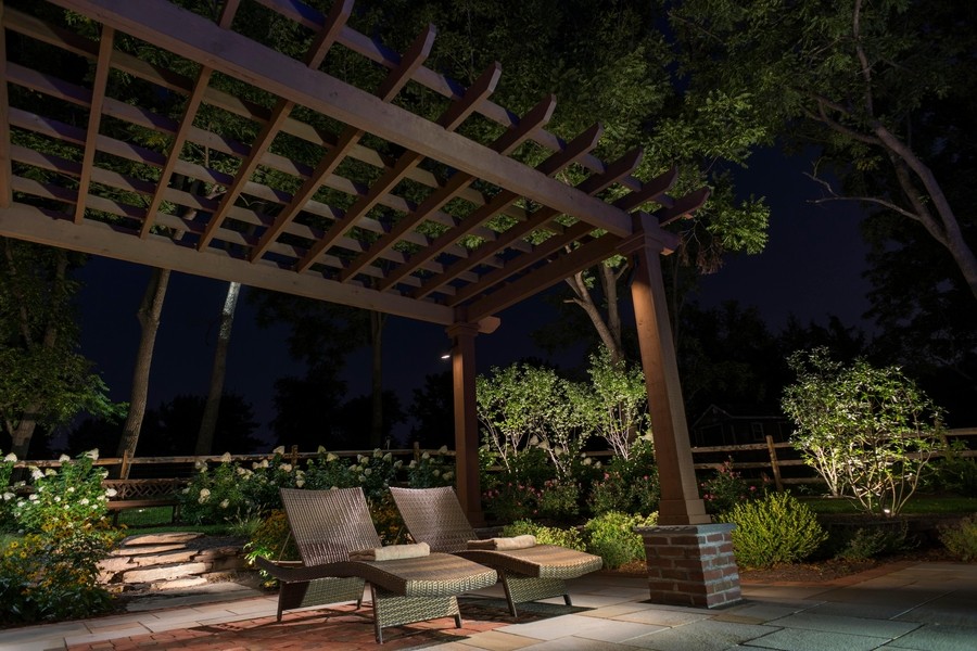 Backyard patio area with two lounge chairs illuminated by Coastal Source fixtures