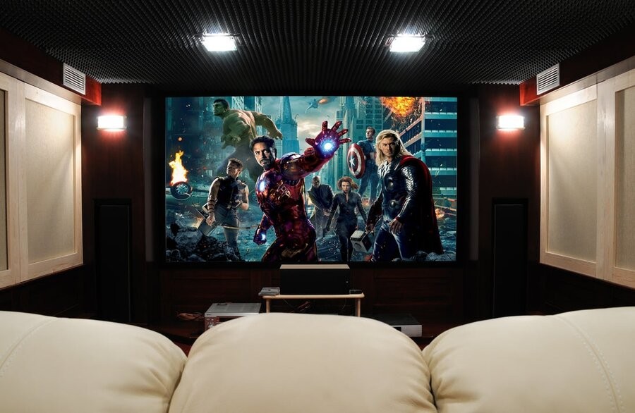  A home theater with a large display showcasing the film Avengers. Blurb: Your favorite media deserves the best environment to view and experience it in - and a home theater is the perfect setting for your next movie night, TV show marathon, and more!