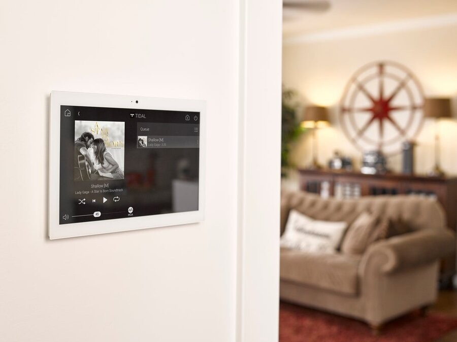 A Control4 wall panel showcasing a whole-home audio interface.