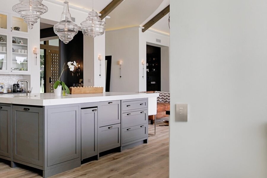 A kitchen space with Lutron lighting fixtures with a Lutron keypad on a nearby wall.