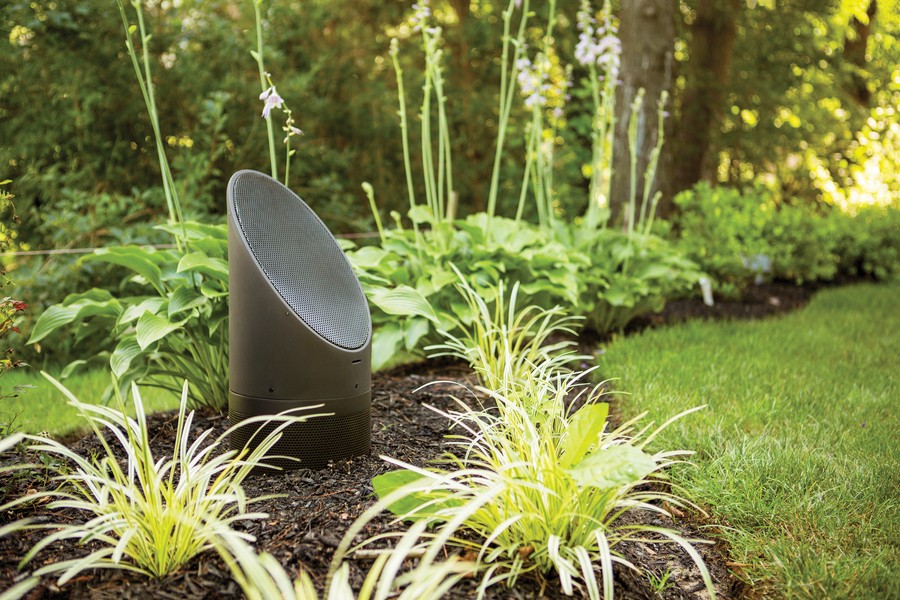 Coastal Source 3-Way Bollard speaker sitting among backyard landscaping. 