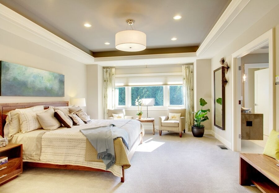 A bedroom with a large window and several ceiling lighting fixtures.