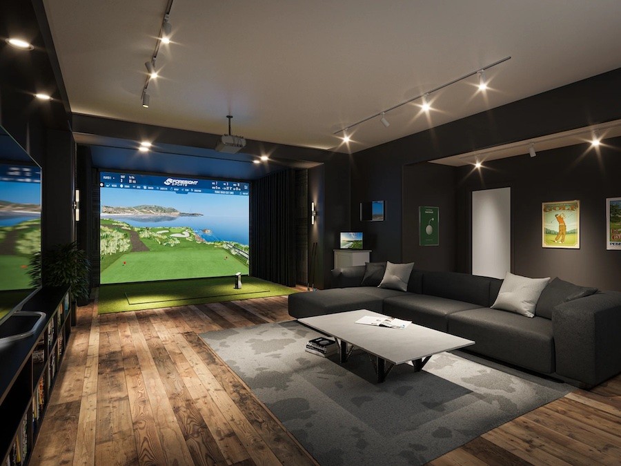 A basement with a golf simulator for home in the corner. 