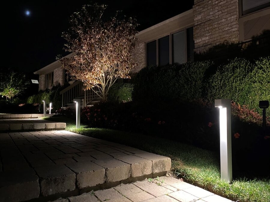 Coastal Source landscape lighting fixtures illuminating a home’s exterior pathway.