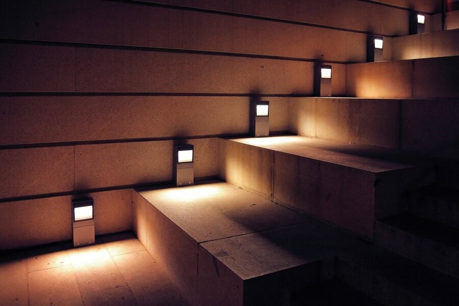 An outdoor stairway illuminated by exterior lighting fixtures.